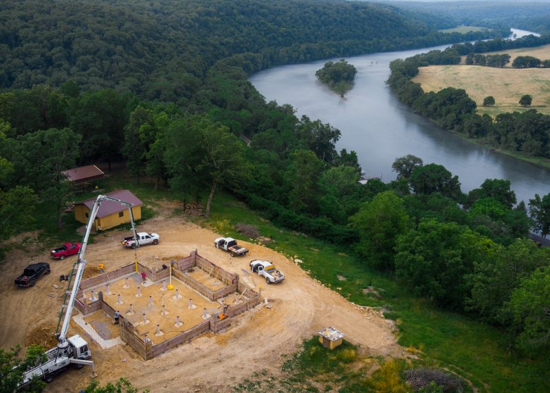 Aerial view of a custom home foundation overlooking the river